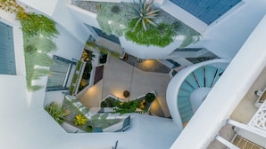 Un edificio moderno con varios niveles, una escalera de caracol y plantas de interior.