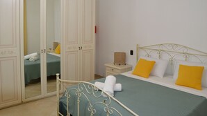 Une chambre à coucher comprenant un lit, une table de chevet, une armoire et un miroir.