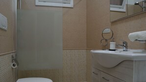 Une salle de bain avec des toilettes, un lavabo et une douche.