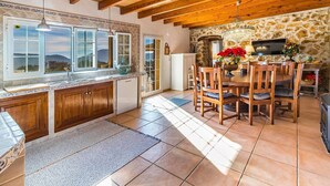 A kitchen with wooden cabinets, a tiled backsplash, and a stone wall. - Finca Andratx con Total Privacidad y Piscina (Andratx)