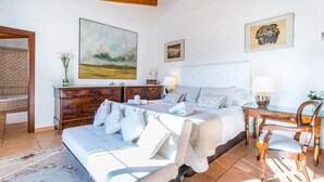 A bedroom with a bed, bedside tables, a desk, and chairs. - Finca Andratx con Total Privacidad y Piscina (Andratx)