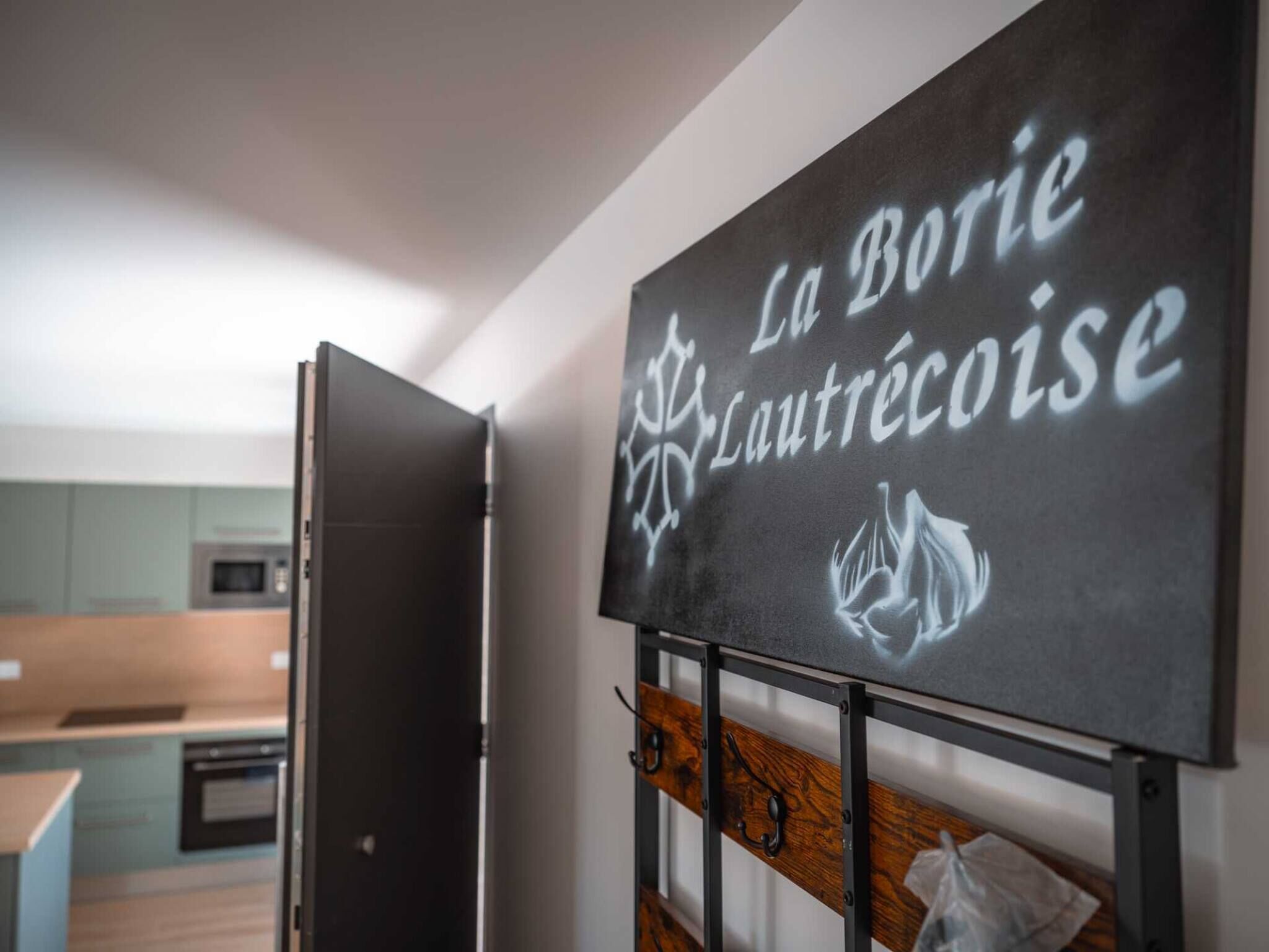 A kitchen with a microwave, a wooden bench, and a sign that reads "La Borie Laurentéoise".