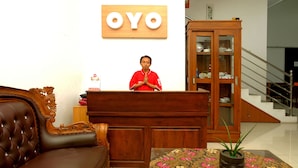 Un comptoir d’accueil avec un meuble en bois et une enseigne indiquant « OYO ».