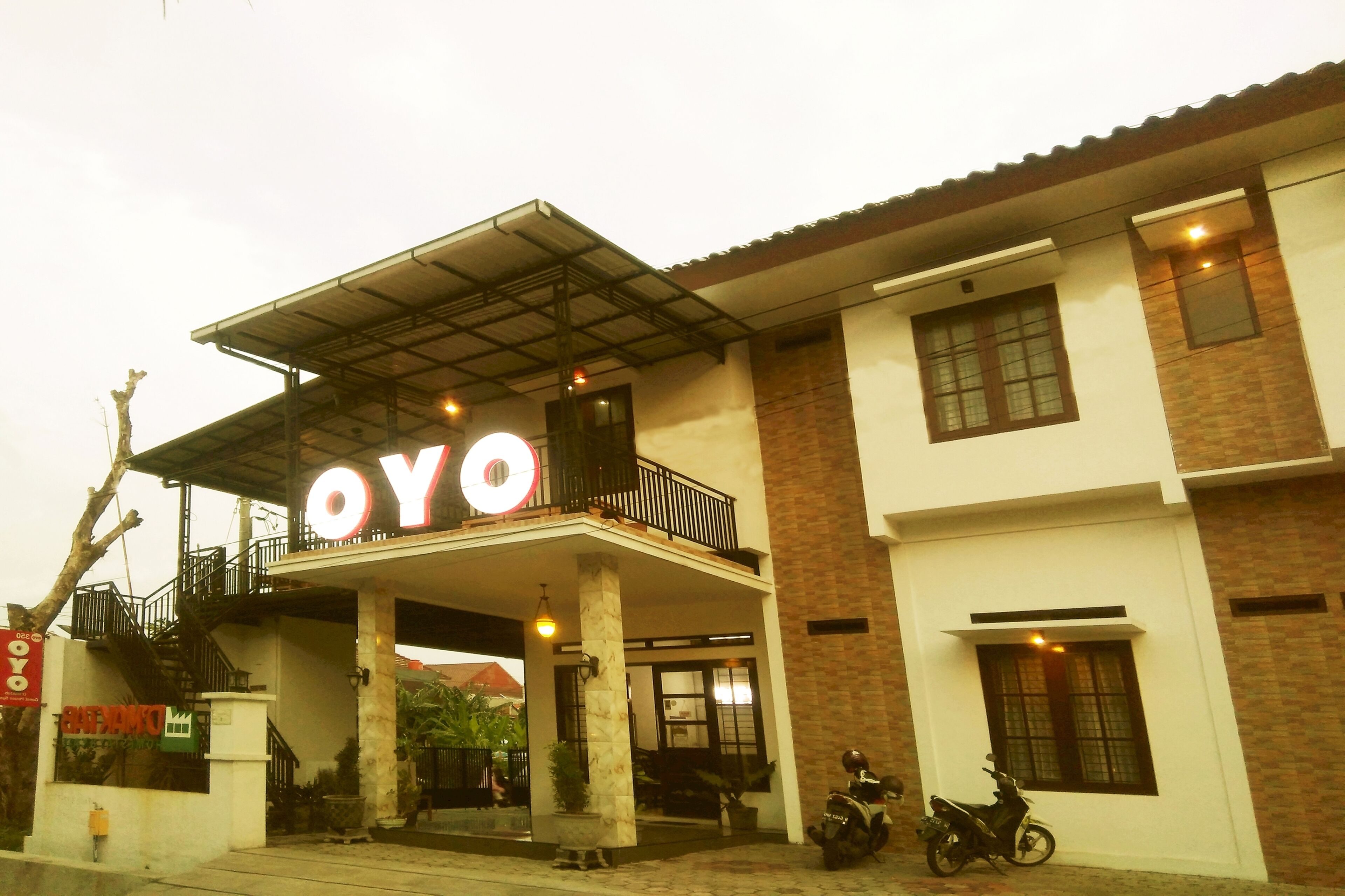 A building with a prominent 'YO' sign, a covered entrance, and a parked scooter.