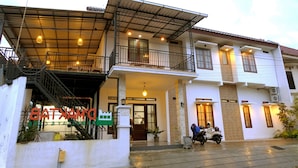 Un bâtiment à deux étages doté d’une entrée abritée et d’un balcon.
