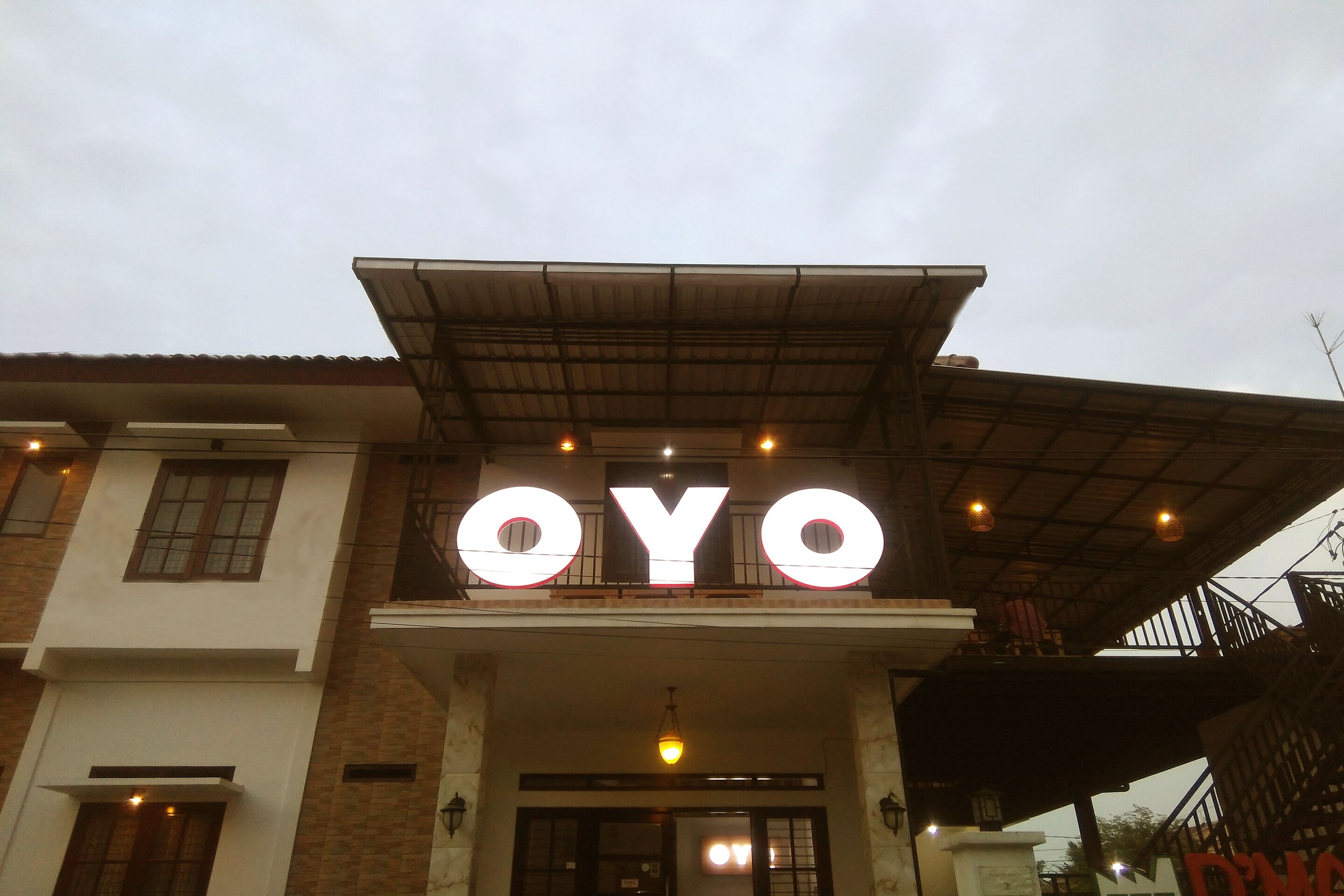 Un bâtiment sur lequel est apposée une grande enseigne lumineuse portant l’inscription « OYO ».