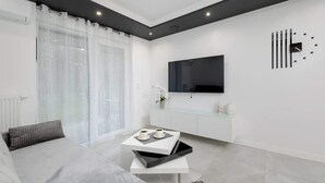 Una sala de estar moderna con un sofá, una mesa de centro, un televisor y una decoración minimalista.