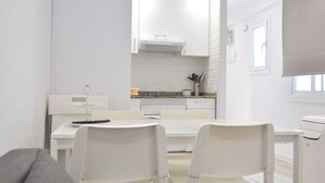 Una cocina moderna con armarios blancos, una estufa empotrada y una ventana sobre el fregadero.