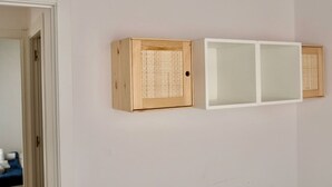 Una habitación con un armario de madera y un armario blanco junto a la pared.