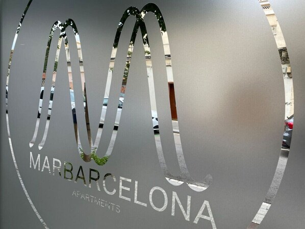 A logo with a stylized 'M' and the text 'MARBARCELONA APARTMENTS'.