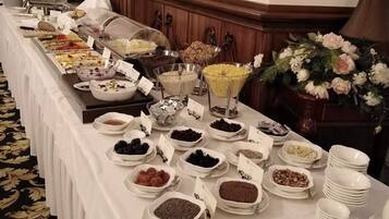 Una mesa de buffet con diferentes platos y una decoración floral.