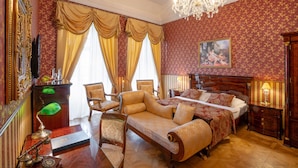 A luxurious bedroom with a large bed, a sitting area, and a desk with a telephone. - Galicia Nueva castle hotel (Halic)