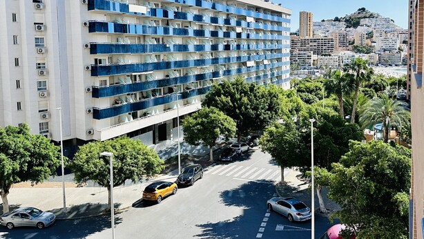 Un hôtel à plusieurs étages doté de balcons, d  ’un parking et offrant une vue sur un paysage urbain vallonné.