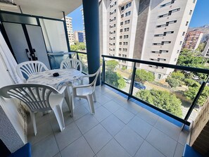 A balcony with a table and chairs, offering a view of surrounding buildings and greenery. - A1047 - Nice apartment in a complete urbanisation and close to the beach (Villajoyosa)
