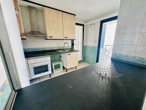 A compact kitchen with a stove, oven, and a sink. - A1047 - Nice apartment in a complete urbanisation and close to the beach (Villajoyosa)