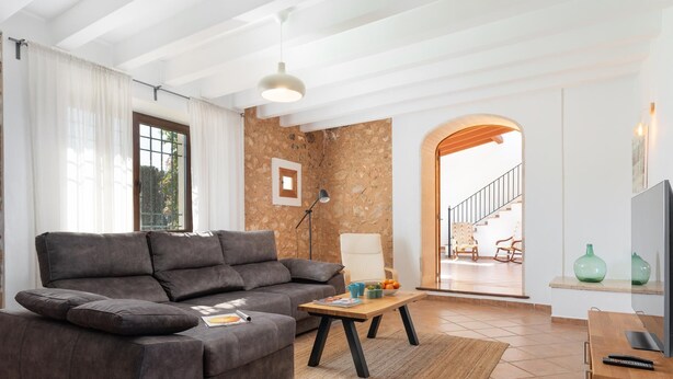 A modern living room with a grey sofa, a coffee table, and a TV stand.