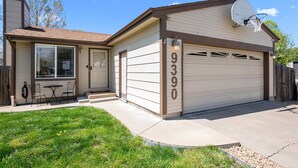A single-story house with a garage, a patio with outdoor seating, and a clear sky. - New! Recently Updated- Near Parks & Rec Center, Fenced Yard- 30 Day Rental (Littleton)
