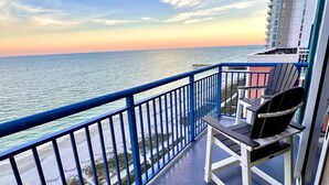 A balcony with a view of the ocean and a pier, featuring a chair and a table. - Paradise Peak/New/Prime Location (Myrtle Beach)