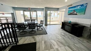 A spacious lobby with a marble floor, a fireplace, and a view of the beach through large glass doors. - Paradise Peak/New/Prime Location (Myrtle Beach)