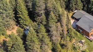 Eine Luftaufnahme einer Anlage mit einem Steg, der sich in ein Gewässer erstreckt, umgeben von dichtem Wald.