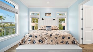 Un dormitorio con cama, dos ventanas, una puerta y vistas al exterior.