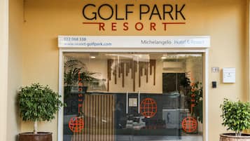 A entrada do Resort Golf Park, com uma placa visível exibindo o nome do resort, número de contato e site.