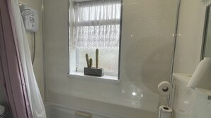 A bathroom with a bathtub, toilet, and sink. - Comfy One Bedroom Apartment  (Darlaston)
