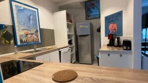 Uma cozinha moderna com bancada de madeira, forno embutido e geladeira.