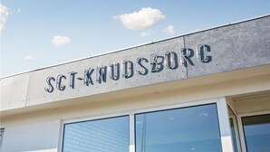 The exterior of a building with the sign "SCT-KNUDSBORG".