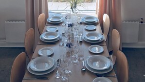 A dining table set for six with a view of the beach.