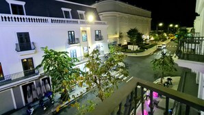 A nighttime view of a hotel with multiple floors, balconies, and a well-lit street below. - Thu Le Hotel (Cao Lanh)