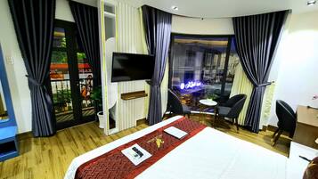 Une chambre d’hôtel avec un lit, une télévision, un bureau et une vue sur la ville.