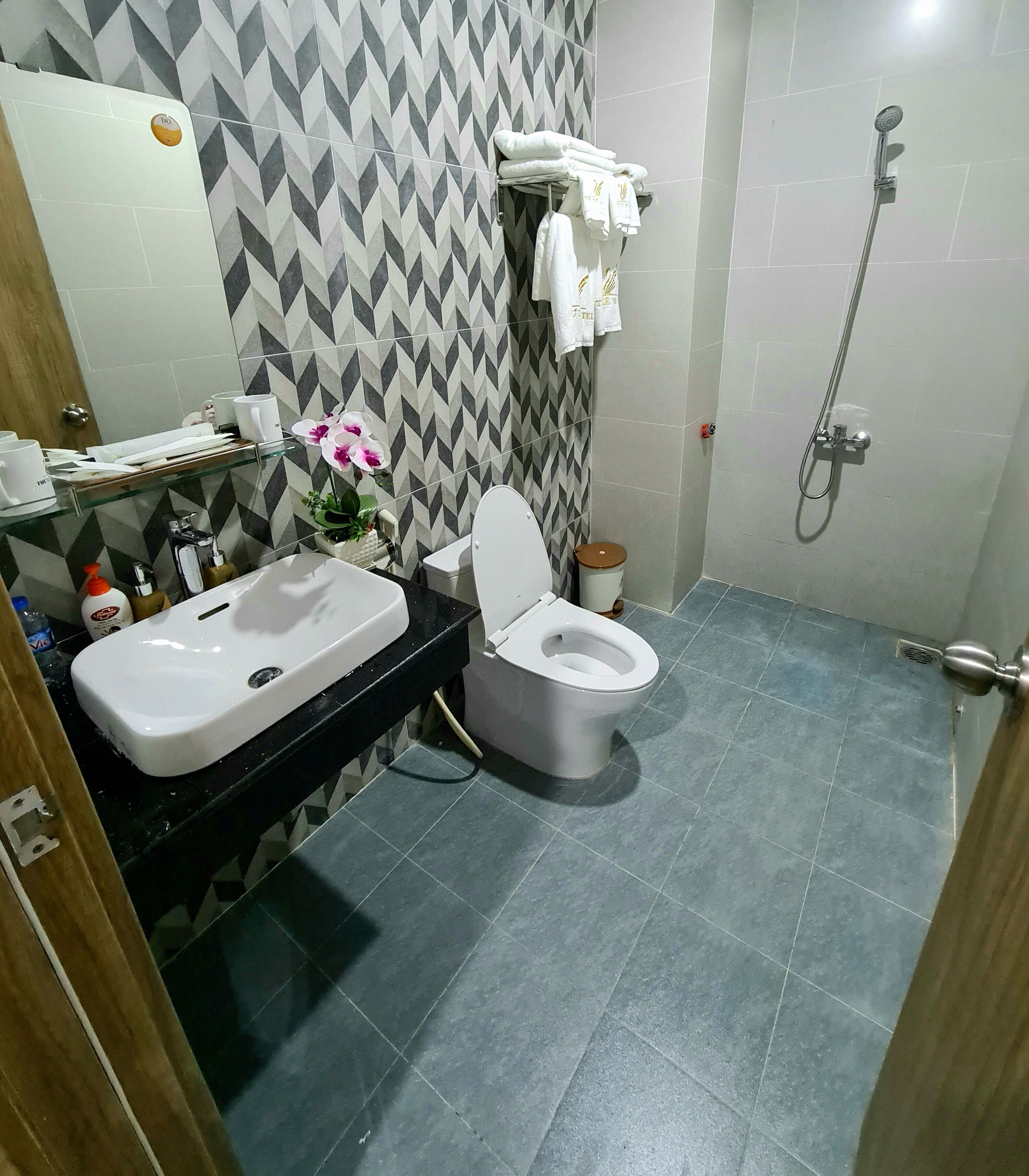 A bathroom with a toilet, sink, and shower.