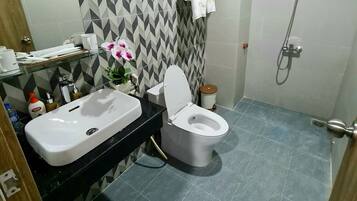 A bathroom with a toilet, sink, and shower.
