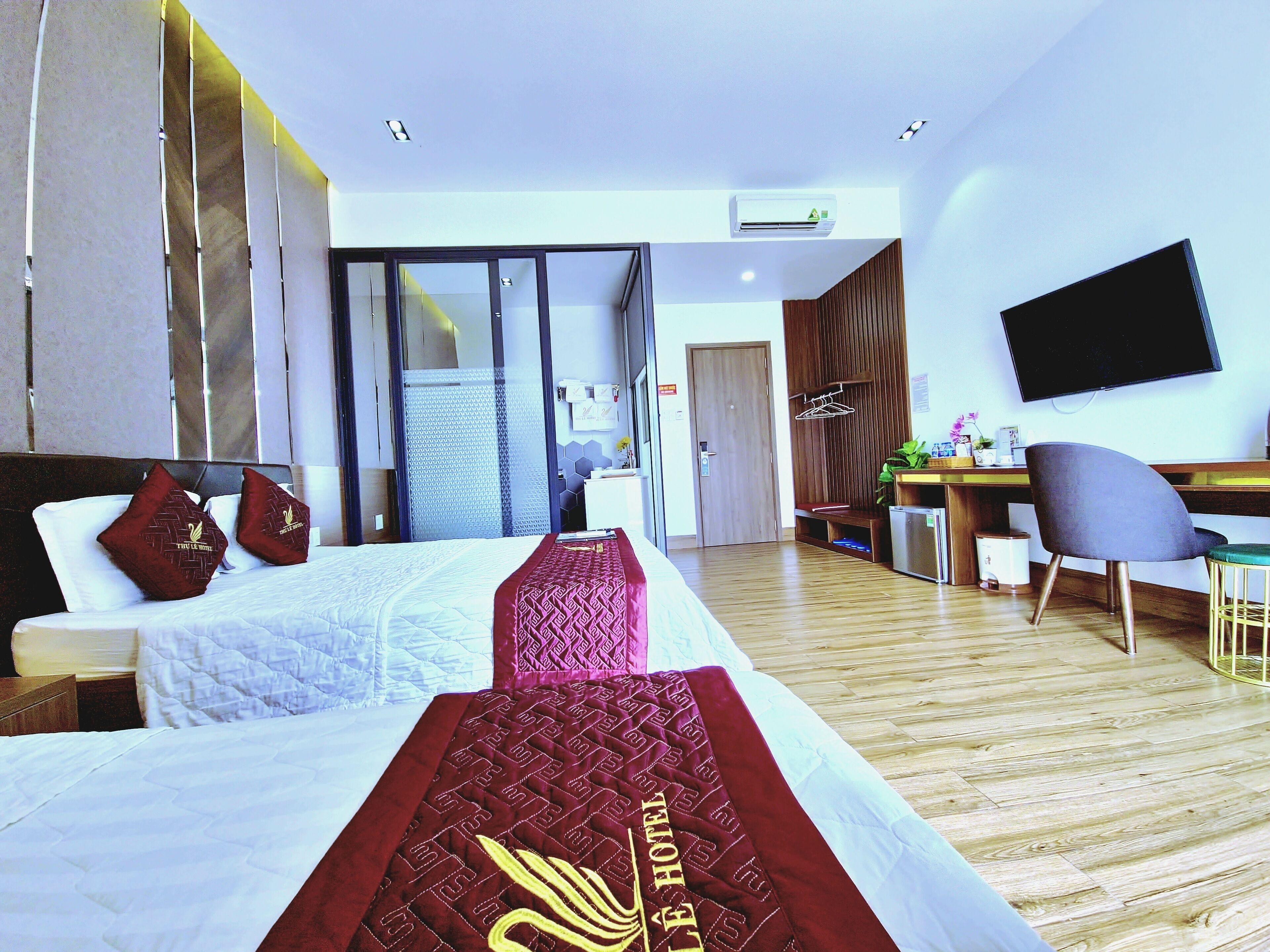 Une chambre d’hôtel avec un lit, un bureau, une chaise et un téléviseur.