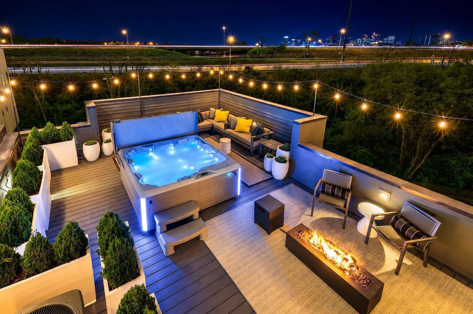 An outdoor deck with a hot tub, seating area, and fire feature.