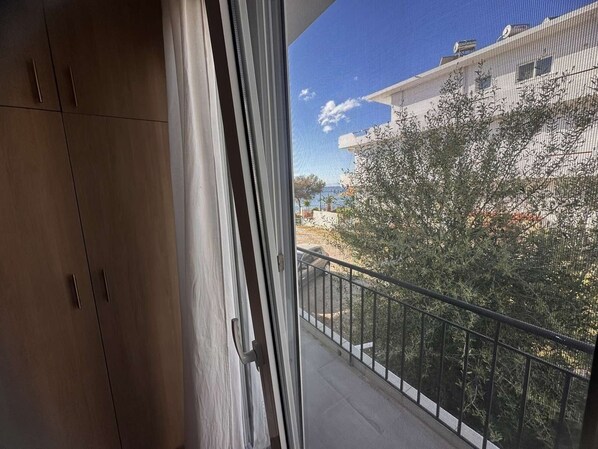 Ein Balkon mit Blick auf ein Gebäude und Bäume.