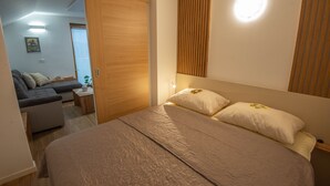 Ein Schlafzimmer mit einem Bett, einem Nachttisch, einer Lampe und einem Holzschrank.