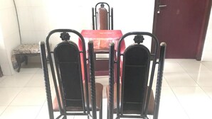 A dining area with a red table and two black metal chairs. - Hotel O Wisma Gading Syariah (Pemalang)