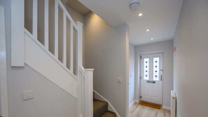 A staircase with white railings leading to a door with diamond-patterned glass. - Dings: Central Bristol House by STAE-Homes (Bristol City)