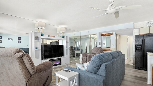 A modern living room with a flat-screen TV, a sofa, and a coffee table. - Sunchaser 407 - 2br/2baths at 36th St, steps to beach, elevator &2 car parking (Ocean City)