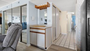 A compact kitchen with a wooden countertop, a built-in oven, and a sliding door leading to a living area. - Sunchaser 407 - 2br/2baths at 36th St, steps to beach, elevator &2 car parking (Ocean City)