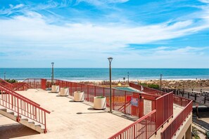 A rooftop terrace with a pool, red railings, and a view of the beach and ocean. - Oceanfront for 9 people at the Rainbow / outdoor pool (Ocean City)