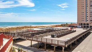 A rooftop deck with picnic tables and a view of the beach and ocean. - Oceanfront for 9 people at the Rainbow / outdoor pool (Ocean City)