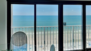 Ein Balkon mit Blick auf das Meer und den Strand.