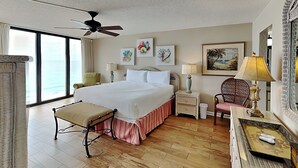 A hotel room with a large bed, a ceiling fan, a view of the ocean, and artwork on the walls. - Edgewater Tower III #1111 | Waterfront Condo, Gulf Views + Great Amenities! (Panama City Beach)