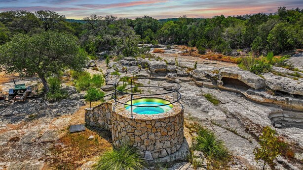 A natural hot spring surrounded by rocky terrain and trees. - Expansive Ranch on 2,001 Acres | Shared Pool & Hot Tub + Trails (Johnson City)
