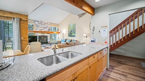 A modern kitchen with granite countertops, wooden cabinets, and a built-in sink. - Nature Adventure with Access to Exclusive Golf (Sunriver)
