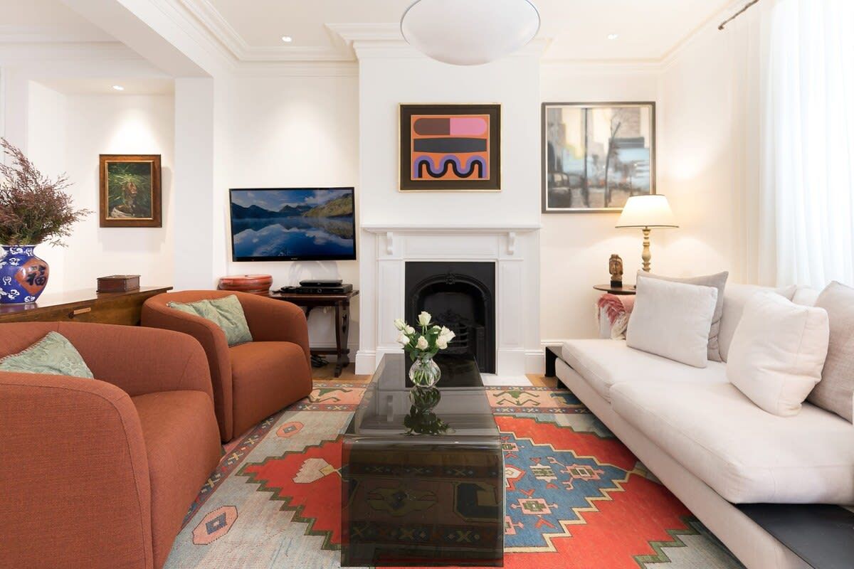 A living room with a fireplace, a sofa, a coffee table, and a TV.