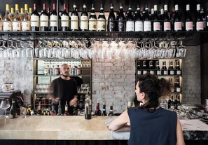 A bar with shelves of wine bottles and glasses.